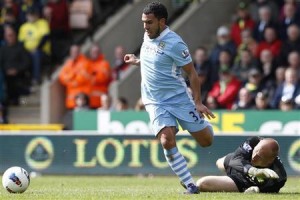 Tevez of Manchester City gets around Ruddy of Norwich City to score his hat trick during their English Premier League soccer match in Norwich