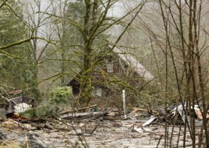 A home located off Highway 530 is surrounded by mud and debris as search work continues from a massive landslide that struck Oso near Darrington, Washington