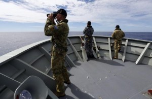 Gunner Brown of Transit Security Element looks through binoculars as he stands on lookout with other crew members aboard Australian Navy ship HMAS Perth as they continue to search for missing Malaysian Airlines flight MH370