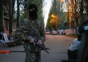 A pro-Russian armed man stands guard at a barricade near the state security service building in Slaviansk