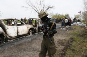 Pro-Russian militant walks near a checkpoint which was the scene of a gunfight overnight near the city of Slaviansk