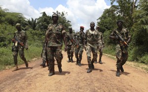 Fighters from the Republican Forces rebels walk at the village of Pekanhouebly on the border of Ivory Coast and Liberia