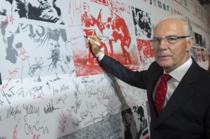 Former player and coach Franz Beckenbauer signs a wall of fame at gala marking 50th anniversary of foundation of German Bundesliga soccer league in Berlin