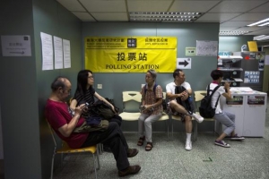 People wait to vote at a polling station during an last day of civil referendum held by the Occupy Central organisers in Hong Kong