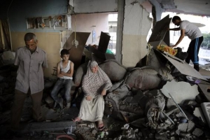 A Palestinian family gathers inside their damaged home, which police said was targeted in an Israeli air strike, in Gaza City