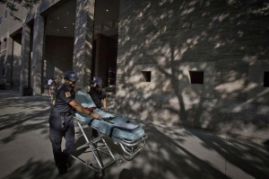 Paramedics wheel a gurney past the entrance of Mount Sinai Hospital in the Manhattan borough of New York