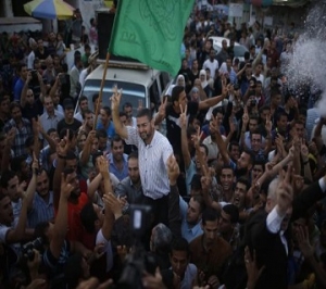 Hamas spokesman Sami Abu Zuhri is carried by Palestinians as they celebrate what they said was a victory over Israel following a ceasefire in Gaza City