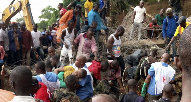 Rescue personnel is seen at the scene of a buiding collapse in Bo on September 26, 2019. STRINGER / AFP