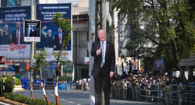 A cutout of US President Donald Trump is seen as people wait beside a street to catch a glimpse of his motorcade in Ahmedabad on February 24, 2020. Mandel NGAN / AFP