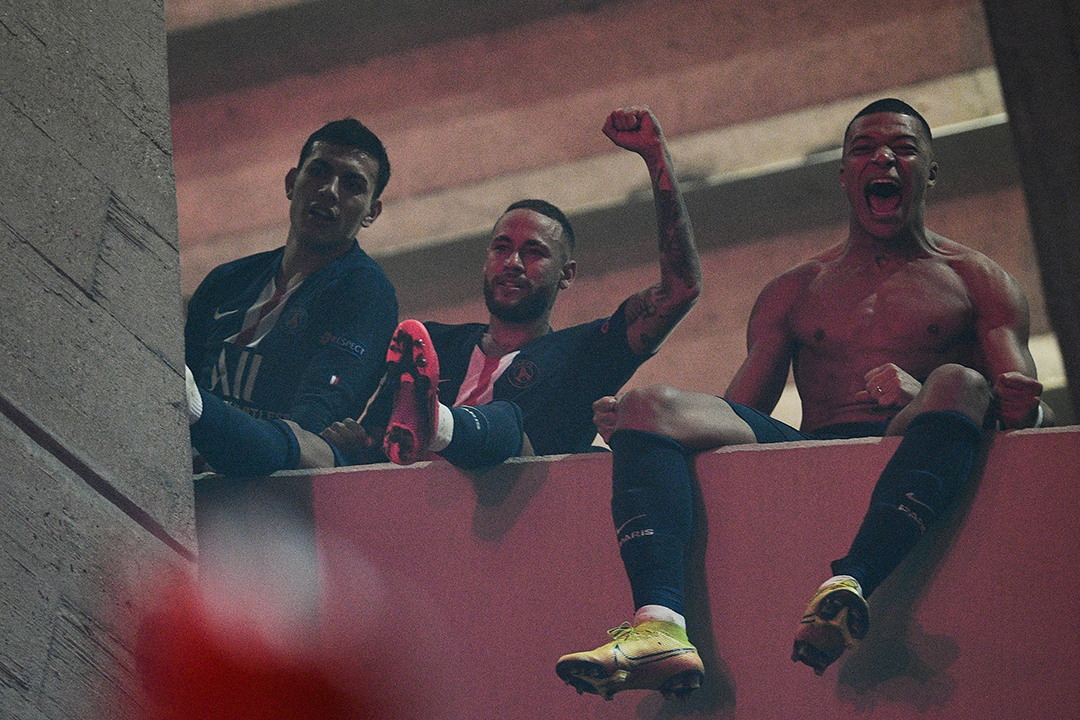 Paris Saint-Germain's Brazilian forward Neymar (C) and Paris Saint-Germain's French forward Kylian Mbappe (R) celebrate with supporters outside the Parc des Princes stadium, in Paris, on March 11, 2020 after winning the UEFA Champions League round of 16 second leg football match between Paris Saint-Germain (PSG) and Borussia Dortmund. - The match between Paris Saint-Germain (PSG) and Borussia Dortmund, is held behind closed doors due to the spread of COVID-19, the novel coronavirus. Photo: Anne-Christine POUJOULAT / AFP