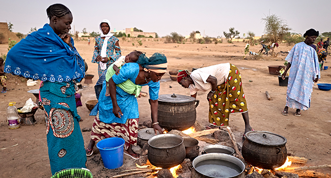 Displaced women prepare the dinner in a courtyard in Sevare in central Mali on February 26, 2020. Two months earlier 400 Dogon people fled their village of Toou finding a shelter in a school of Sevare. MICHELE CATTANI / AFP