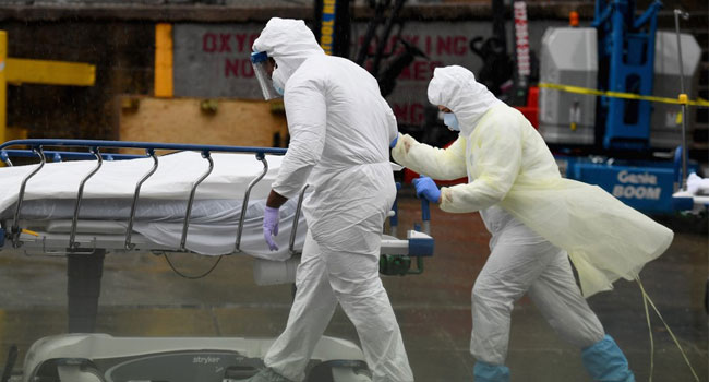 Medical personnel move a deceased patient to a refrigerated truck serving as make shift morgues at Brooklyn Hospital Center on April 09, 2020 in New York City. Angela Weiss / AFP
