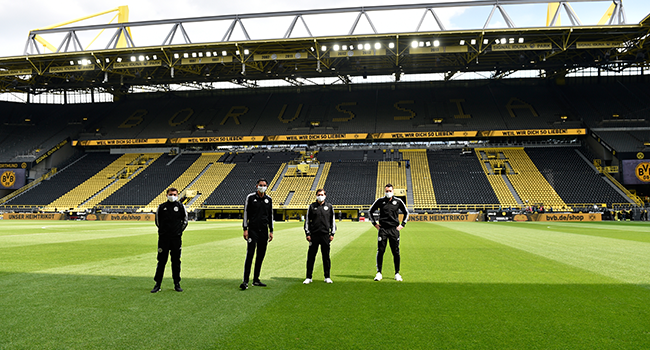 Referee Deniz Aytekin, 2nd left, and his team stand on the pitch prior the German first division Bundesliga football match BVB Borussia Dortmund v Schalke 04 on May 16, 2020 in Dortmund, western Germany as the season resumed following a two-month absence due to the novel coronavirus COVID-19 pandemic. Martin Meissner / POOL / AFP