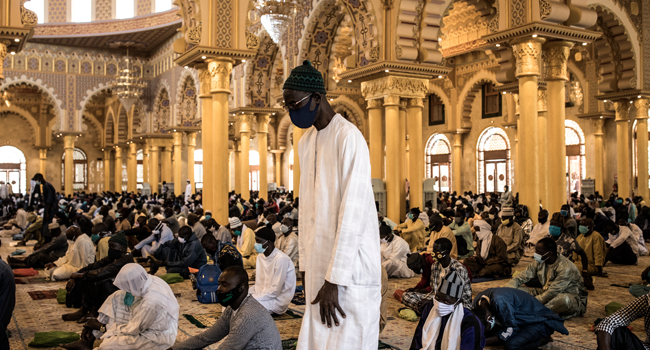 A Muslim worshipper prays before Friday prayers at the Mosque of the Mourides, which open for its first Friday prayers after two months in Dakar on May 15, 2020. JOHN WESSELS / AFP
