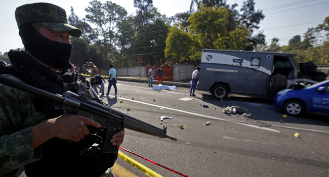 A soldier stands guard next to a security transport truck after it was ambushed by an armed group who killed four private guards in an assault on the Guadalajara-El Arenal highway, Jalisco state, Mexico, on June 19, 2020. ULISES RUIZ / AFP