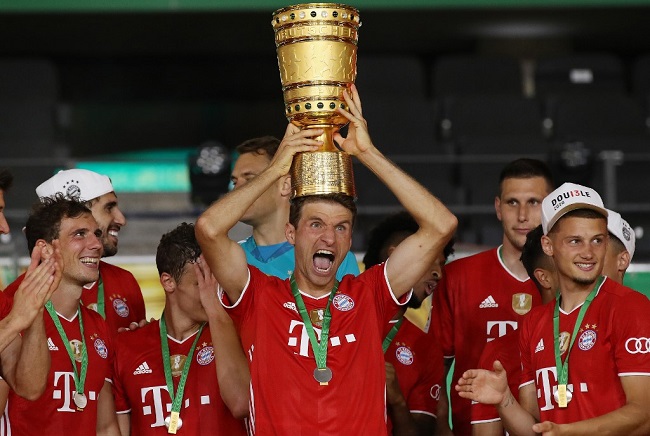 Bayern Munich's German forward Thomas Mueller raises the German Cup (DFB Pokal) trophy as he and his teammates celebrate winning the final football match Bayer 04 Leverkusen v FC Bayern Munich at the Olympic Stadium in Berlin on July 4, 2020. (Photo by Alexander Hassenstein / POOL / AFP)
