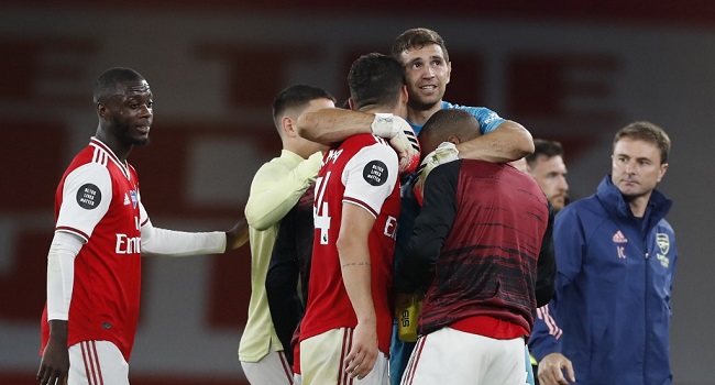 Arsenal's Argentinian goalkeeper Emiliano Martinez (C) celebrates with teammates on the pitch after the English Premier League football match between Arsenal and Liverpool at the Emirates Stadium in London on July 15, 2020. - Arsenal won the game 2-1. (Photo by PAUL CHILDS / POOL / AFP) / RESTRICTED TO EDITORIAL USE. No use with unauthorized audio, video, data, fixture lists, club/league logos or 'live' services. Online in-match use limited to 120 images. An additional 40 images may be used in extra time. No video emulation. Social media in-match use limited to 120 images. An additional 40 images may be used in extra time. No use in betting publications, games or single club/league/player publications. /