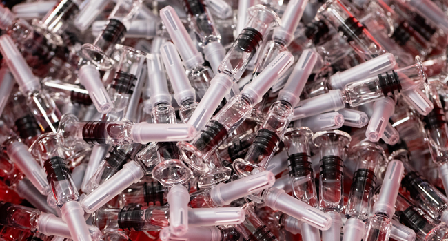 In this file photo taken on July 10, 2020 A photo shows vaccines in prefilled, single-use syringes before the inspection and packaging phase at the French pharmaceutical company Sanofi's world distribution centre in Val de Reuil, France. JOEL SAGET / AFP