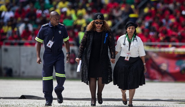 Zenani Mandela-Dlamini, a daughter of the late anti-apartheid icon Winnie Madikizela-Mandela, is escorted by medical staff after making her speech during her mother's funeral at the Orlando Stadium in the township of Soweto, concluding 10 days of national mourning on April 14, 2018, in Johannesburg. - South Africans turned out in their thousands to bid final goodbyes to the anti-apartheid icon and Nelson Mandela's former wife who was laid to rest with full state honours. Winnie Mandela, who died in Johannesburg aged 81 on April 2 after a long illness, has been celebrated for helping keep Nelson Mandela's dream of a non-racial South Africa alive while he was behind bars for 27 years. (Photo by Wikus DE WET / AFP) /