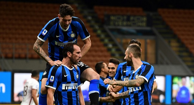 Inter Milan's Uruguayan defender Diego Godin(L) celebrates with Inter Milan's Italian defender Alessandro Bastoni(top) and Inter Milan's Croatian defender Marcelo Brozovic after scoring his team's second goal during the Italian Serie A football match Inter Milan vs Torino played behind closed doors on July 13, 2020 at the San Siro stadium in Milan. (Photo by MIGUEL MEDINA / AFP)