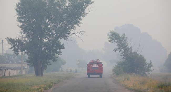 A fire truck drives on a road in the area hit by wildfires in the Lugansk region on July 8, 2020. Aleksey Filippov / AFP