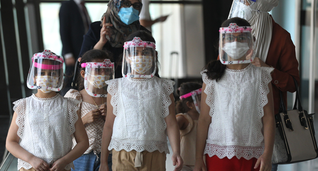 An Iraqi family wearing protective masks walk at the departure hall of Baghdad international airport following its reopening on July 23, 2020, after a closure forced by the coronavirus pandemic restrictions aimed at preventing the spread of the deadly COVID-19 illness in Iraq. AHMAD AL-RUBAYE / AFP