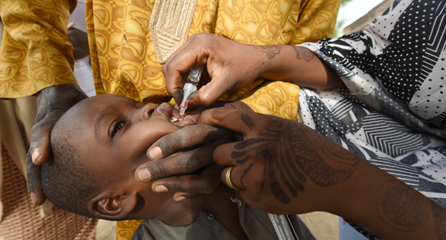 In this file photo taken on April 22, 2017 A Health worker administers a vaccine to a child during a vaccination campaign against polio at Hotoro-Kudu, Nassarawa district of Kano in northwest Nigeria. PIUS UTOMI EKPEI / AFP