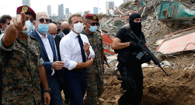 French President Emmanuel Macron (C), surrounded by Lebanese servicemen, visits the devastated site of the explosion at the port of Beirut, on August 6, 2020 two days after a massive explosion devastated the Lebanese capital in a disaster that has sparked grief and fury. Thibault Camus / POOL / AFP