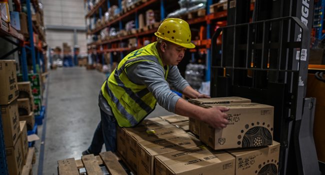 In this picture taken on November 6, 2020, an employee works in the warehouse of Cainiao Smart Logistics Network, the logistics affiliate of e-commerce giant Alibaba, in Wuxi, China's eastern Jiangsu province, ahead of Singles' Day, also known as the Double 11 shopping festival - the world's biggest shopping event - which falls on November 11. Hector RETAMAL / AFP