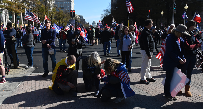 Supporters of US President Donald Trump pray during a rally rally in Washington, DC, on November 14, 2020. Supporters are backing Trump's claim that the November 3 election was fraudulent. Andrew CABALLERO-REYNOLDS / AFP