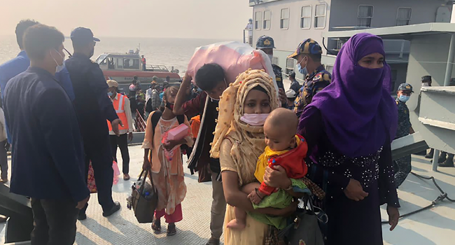Rohingya refugees disembark from a Bangladesh Navy ship to the island of Bashar Char in Noakhali on December 4, 2020. Stringer / AFP