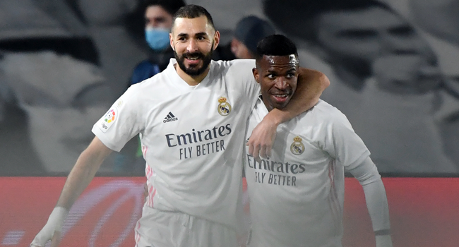 Real Madrid's French forward Karim Benzema (L) celebrates his goal with Real Madrid's Brazilian forward Vinicius Junior during the Spanish league football match between Real Madrid CF and Granada FC at the Alfredo di Stefano stadium in Valdebebas, on the outskirts of Madrid on December 23, 2020. OSCAR DEL POZO / AFP