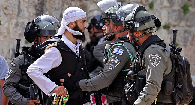 A Palestinian argues with Israeli security forces in Jerusalem's Old City on May 10, 2021, ahead of a planned march to commemorate Israel's takeover of Jerusalem in the 1967 Six-Day War. EMMANUEL DUNAND / AFP