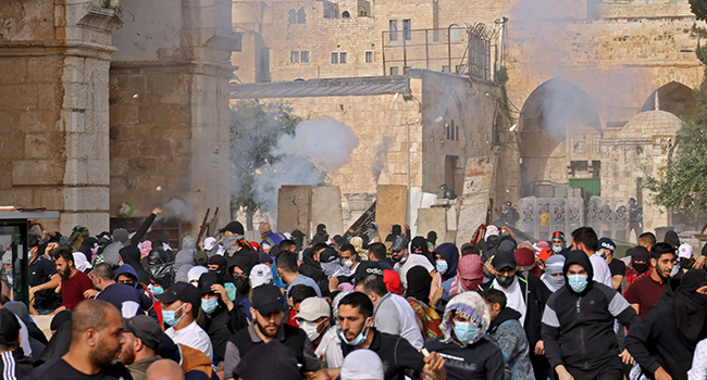 Palestinians run for cover from tear gas fired by Israeli security forces in Jerusalem's Old City on May 10, 2021, ahead of a planned march to commemorate Israel's takeover of Jerusalem in the 1967 Six-Day War. ahmad gharabli / AFP