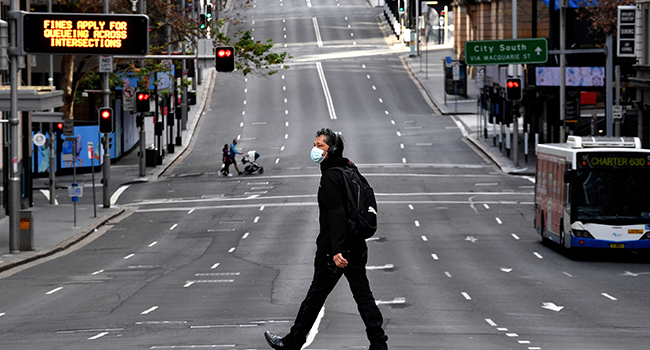 A man walks along the main road in the central business district of Sydney on June 26, 2021, as Australia's largest city entered a two-week lockdown to contain an outbreak of the highly contagious Delta variant. Saeed KHAN / AFP