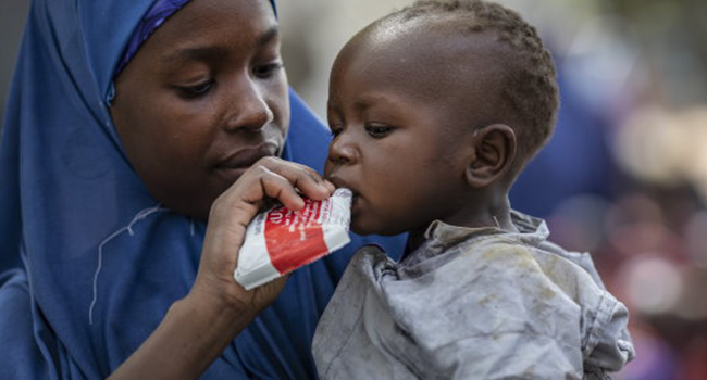 Modola, Aisha, 25, feeds her baby boy Sadiki, 1 with Plumpy'Nut, a peanut-based paste for treatment of severe acute malnutrition, in an IDP camp in Bama, Borno state. Photo: WFP/Siegfried-