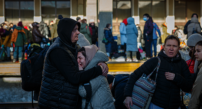 A man hugs his wife before she boards an evacuation train at Kyiv central train station on February 28, 2022. Dimitar DILKOFF / AFP