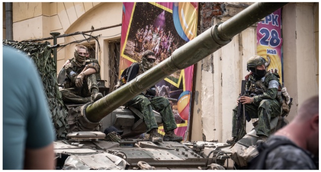 Members of Wagner group sit atop of a tank in a street in the city of Rostov-on-Don, on June 24, 2023. (Photo by Roman ROMOKHOV / AFP)