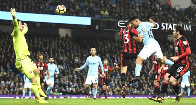 Manchester City's Argentinian striker Sergio Aguero (R) heads the ball to score their third goal during the football match against Bournemouth at the Etihad Stadium on December 23, 2017. Oli SCARFF / AFP