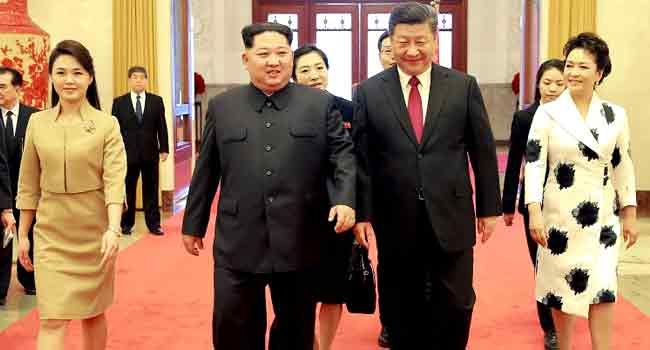 This picture from North Korea's official Korean Central News Agency (KCNA) taken on March 26, 2018 and released on March 28, 2018 shows China's President Xi Jinping (2nd R), his wife Peng Liyuan (R), North Korean leader Kim Jong Un (2nd L) and his wife Ri Sol Ju (L) walking in the Great Hall of the People in Beijing. KCNA VIA KNS / AFP