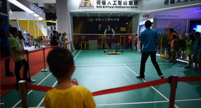 A robot plays badminton with a man at the 2018 World Robot Conference in Beijing on August 15, 2018.  WANG Zhao / AFP