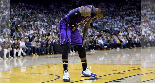 LeBron James #23 of the Los Angeles Lakers leans over in pain after he was hurt against the Golden State Warriors during the second half of their NBA Basketball game at ORACLE Arena on December 25, 2018 in Oakland, California. LeBron James left with a groin injury but the Los Angeles Lakers regrouped for a 127-101 blowout win over two-time defending champion Golden State that snapped an 11-game losing streak on the Warriors' home court. Thearon W. Henderson / GETTY IMAGES NORTH AMERICA / AFP