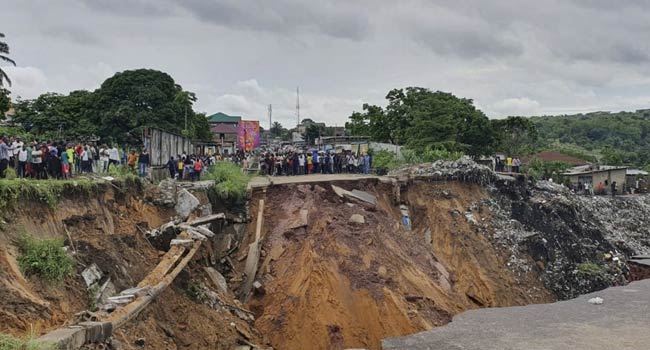 A road surface swept away by a landslide caused by torrential overnight rains is photographed in the Lemba district of Kinshasa, on November 26, 2019.