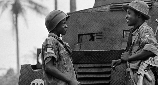 In this file photograph taken on August 31, 1968, a pair of child soldiers of the Biafran army, Moise, 14 (L) and Ferdinand, 16 (R) speak in Umuahia as the Nigerian federal troops continue their advance during the Biafran war. Francois Mazure / AFP