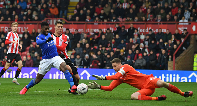 Brentford's English goalkeeper Luke Daniels (R) saves at the feet of Leicester City's Nigerian striker Kelechi Iheanacho (2nd L) during the English FA Cup fourth round football match between Brentford and Leicester City at Griffin Park in west London on January 25, 2020. DANIEL LEAL-OLIVAS / AFP