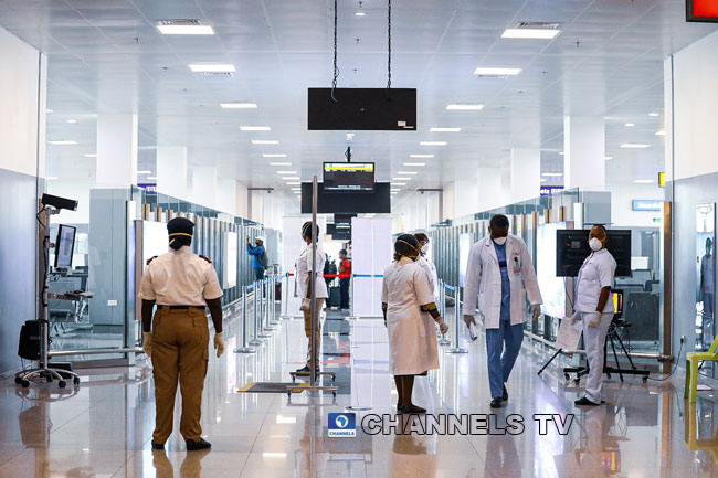 A security official and medical personnel move around at the Nnamdi Azikwe International Airport in Abuja.