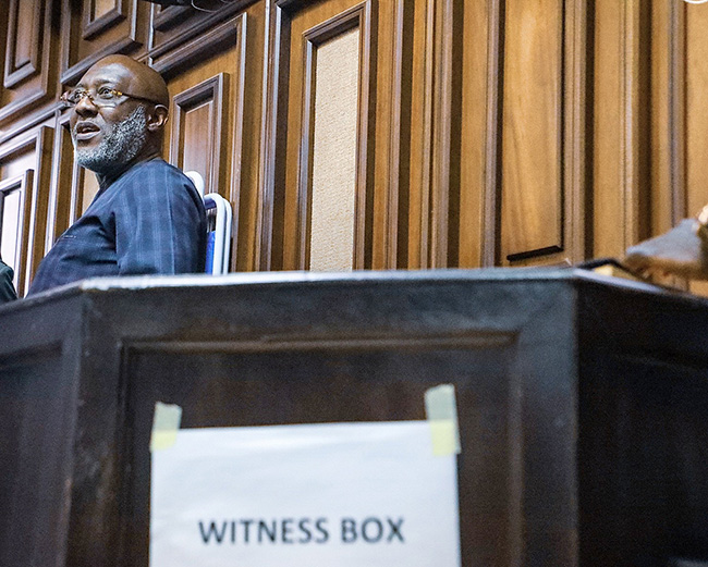 Former PDP spokesman, Mr Olisa Metuh stand inside a dock at the Federal High Court in Abuja on February 25, 2020. Photo: Sodiq Adelakun/Channels TV