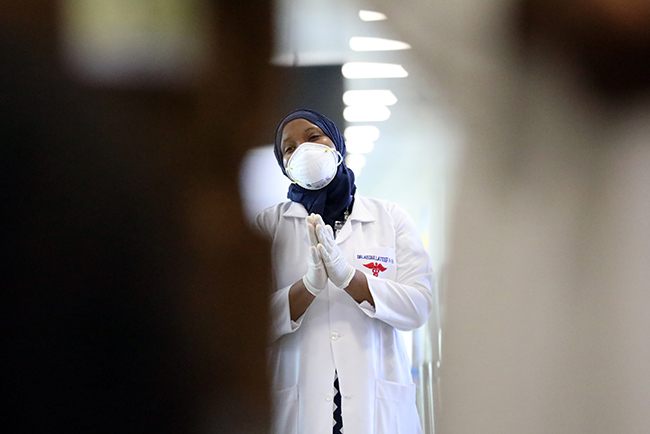 A health worker direct incoming travelers to a check-up section during a supervision process to prevent spread of Corona Virus at the Nnamdi Azikwe International Airport. PHOTO: Sodiq Adelakun