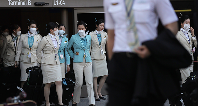 A flight crew from Korean Air, many wearing protective masks, depart the international terminal after arriving at Los Angeles International Airport (LAX) on February 28, 2020 in Los Angeles, California. MARIO TAMA / GETTY IMAGES NORTH AMERICA / AFP