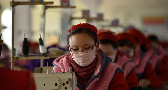 In this photo taken on February 6, 2020, workers of Songyo Knitwear Factory in Pyongyang produce masks for protection against the new coronavirus. Kim Won-Jin / AFP